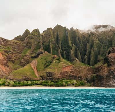 Fluted cliffs above a strip of beach and turquoise water