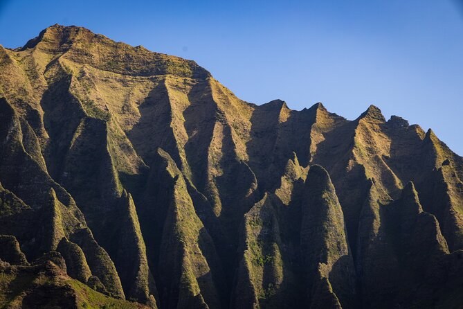 Knife-edge ridges lit by a low sun against a blue sky