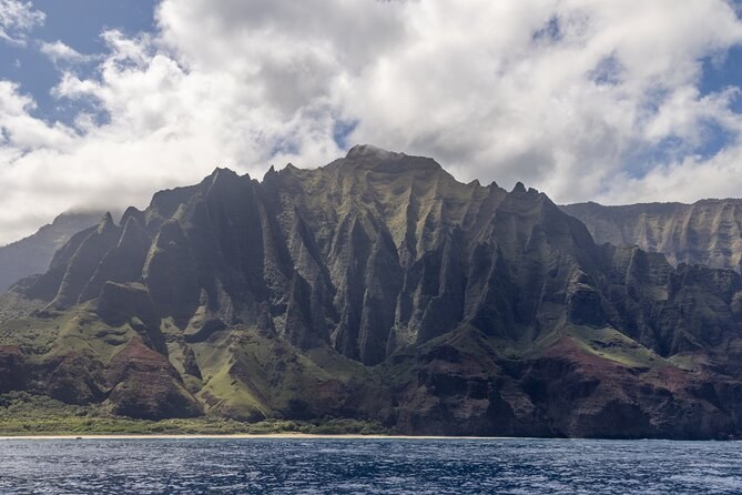 Ridged green cliffs rising from the sea under cloud